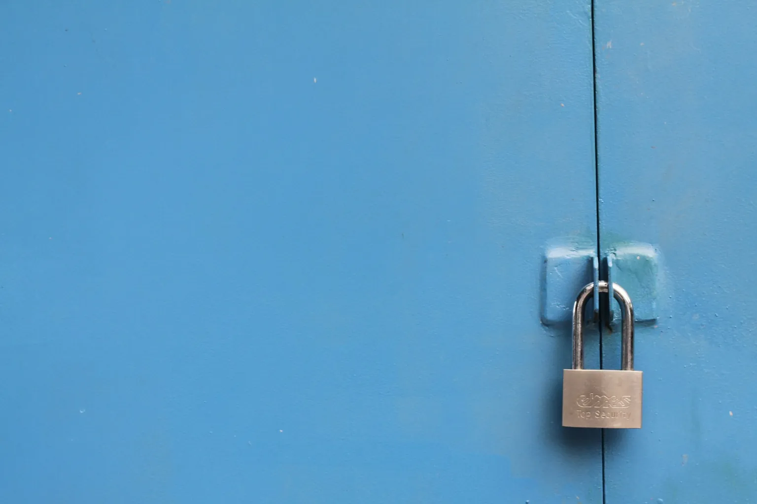 Brass padlock on a blue door